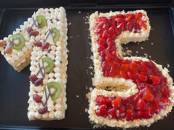 Torte als 15 mit Erdbeeren, Kiwi, Trauben und Mandeln